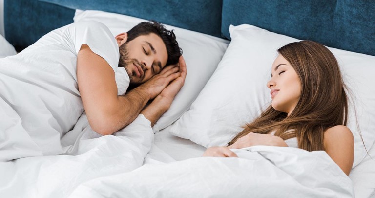 attractive young couple sleeping together in morning